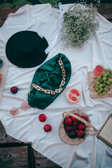 picnic by the lake, white blanket, women's purse, fruit and croissants