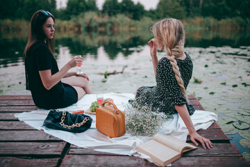 two girls had a picnic by the lake