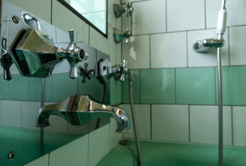 Close up of original green vintage retro 1930s deco wash basin and stainless steel taps.
