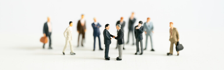 Miniature businessman shake hand partner client customers on stage with success dealing business...