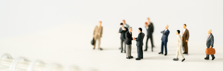 Miniature businessman shake hand partner client customers on stage with success dealing business using as contract commitment agreement investment and partnership business development cover page ads