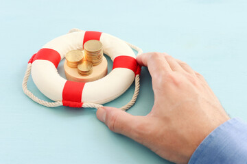 Concept image of lifebuoy and stack of coins. idea and metaphor of financial support in times of...