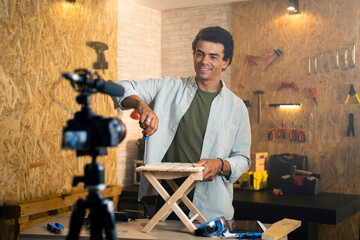 DIY carpenter filming a blog showing how to tighten up a wooden chair