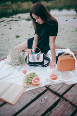 the girl had a picnic on the pier by the lake