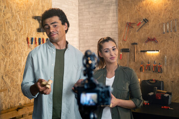 Two people in a carpentry workshop being filmed with a camera for a blog