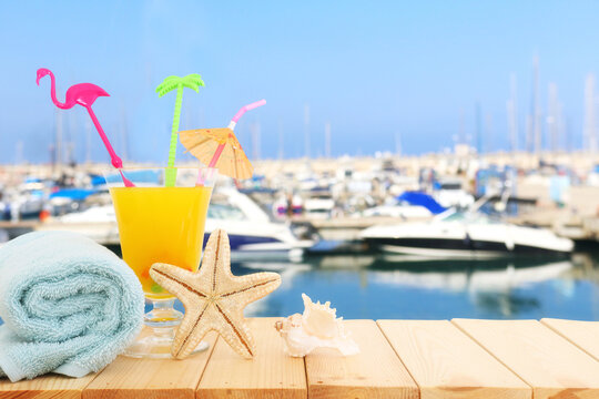 image of tropical and exotic fruit coctail over wooden table infront of sea landscape background