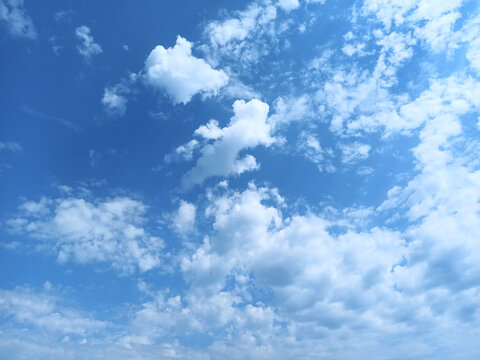 Blue sky with white clouds. Clear sky in the summer. Cloudy landscape. Natural background. Abstract composition with fluffy clouds. Close-up. 4k quality