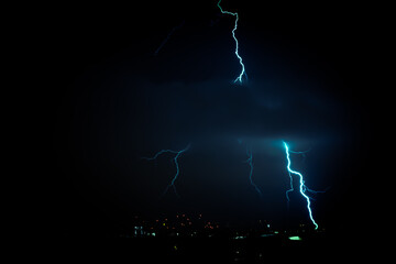 Strong lightning strike above a town at night - perfect for wallpapers and backgrounds