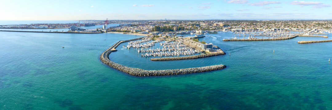 Panoramic shot of Fremantle's Challenger Harbour on a sunny day with boats, yachts. trees and groyne