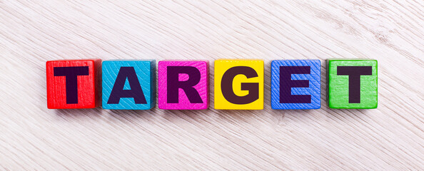 On a light wooden background, multi-colored wooden cubes with the text TARGET.