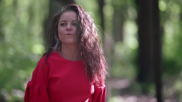 charming brunette woman is walking alone in forest at summer day