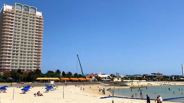 CHATAN-CHO, OKINAWA, JAPAN - JUNE 2021 : View of Chatan sunset beach (Ocean or sea). Wide view, time lapse tracking shot in daytime. Holiday, vacation and resort concept shot.