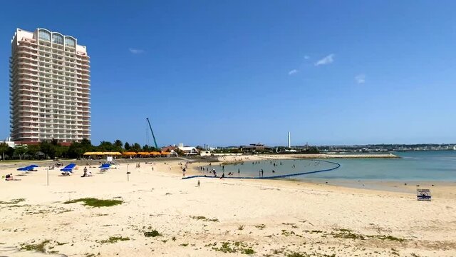 CHATAN-CHO, OKINAWA, JAPAN - JUNE 2021 : View of Chatan sunset beach (Ocean or sea). Wide view, time lapse tracking shot in daytime. Holiday, vacation and resort concept shot.