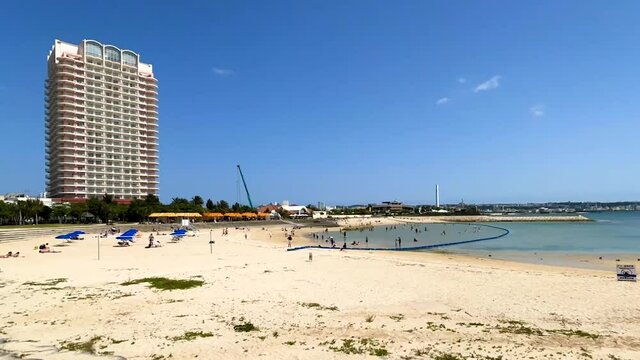 CHATAN-CHO, OKINAWA, JAPAN - JUNE 2021 : View of Chatan sunset beach (Ocean or sea). Wide view, time lapse tracking shot in daytime. Holiday, vacation and resort concept shot.