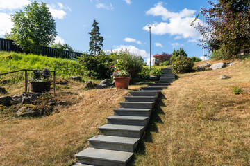 Concrete ladder in the garden. Beautiful garden landscaping. High staircase cement steps,...