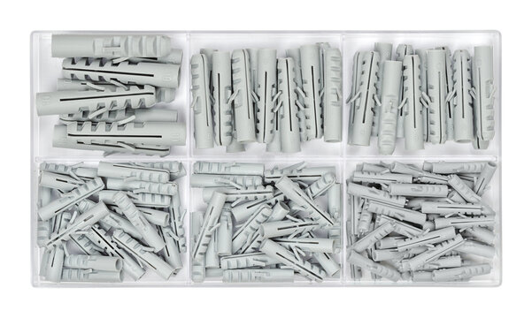 Set of wall plugs in a clear plastic box. Assorted gray anchors or rawlplugs in a container. Plastic insert that allow a screw to be fitted into a wall. Close-up from above, isolated over white. Photo