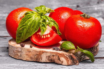 Ripe tomatoes with fresh basil leaves, black salt, and peppercorn