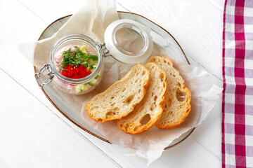 Pieces of bread with fish pate on white wooden table