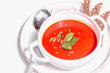 Red puree soup with tomato, greens, and bread