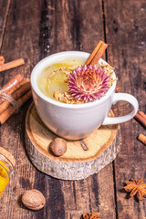 Golden turmeric milk with ice on bright yellow background