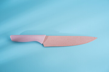 Pink knife on blue background