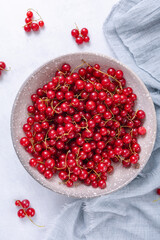 Fresh red currant in wooden bowl on grey table