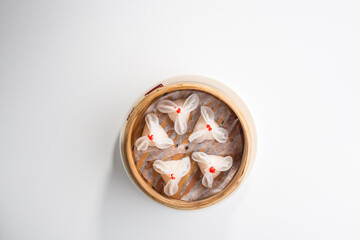 Chinese dim sum dumplings in bamboo basket isolated on white background