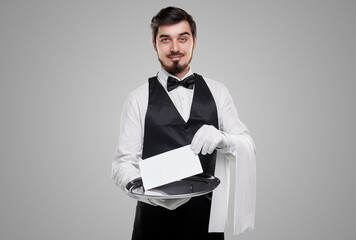 Smiling waiter with tray and reservation sign in studio