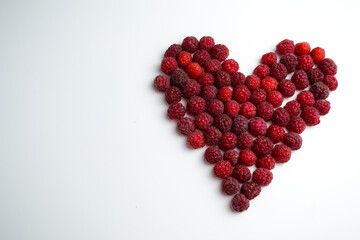 Close-up shot of fresh raspberries in the shape of a heart - perfect for diet and the benefits of natural vitamins for heart and health. Healthy lifestyle.