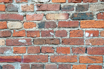 Old weathered red brick wall for texture or background, classic rough aged brickwork, vintage masonry with cement mortar, strong uneven surface, above close-up wallpaper