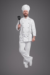 Happy chef with spatula looking at camera