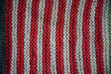 Colored knitted blanket made of wool yarn in stripes and rectangles for home design.