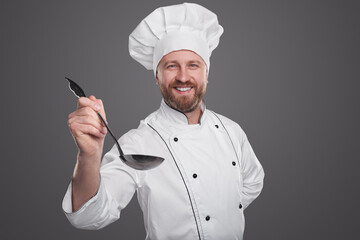 Happy chef with ladle tasting food