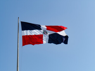 The Dominican flags waving with blue sky in the background