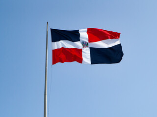 The Dominican flags waving with blue sky in the background