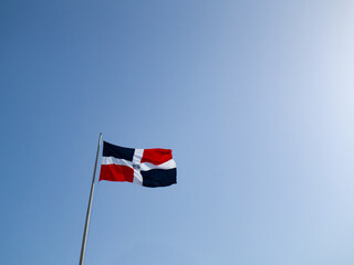 The Dominican flags waving with blue sky in the background