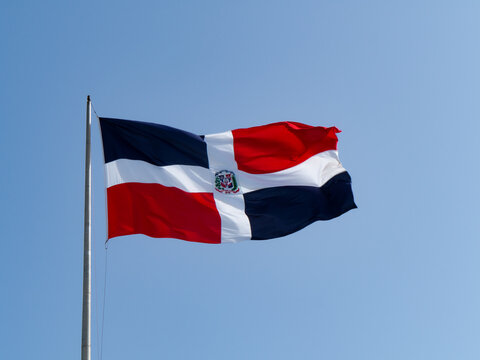 The Dominican flags waving with blue sky in the background