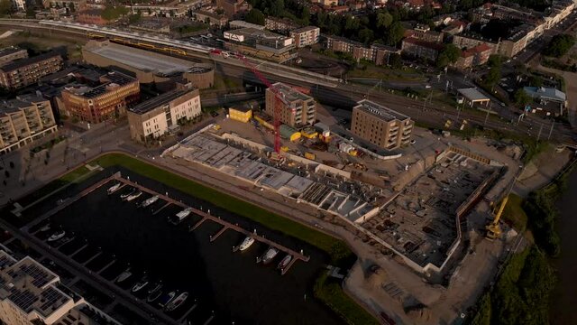 low sideways pan showing luxury apartment complex construction at riverbank of river IJssel. Aerial blueprint view of the new Kade Zuid urban housing development project in former industrial area