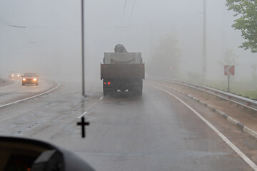 Blur image of the fog after rain.View through the windshield of cars on the asphalt road, wet after the rain, mountains, fog, mist,Trees and grass against a sky with clouds. Soft focus,Select focus