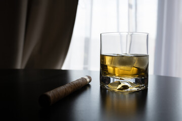 Whisky with ice and sigar on the table 