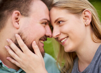 Young happy millennial couple smiling and looking into each other's eyes - Teenager girl touching his boyfriends's face - Love concept