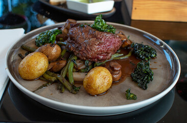 Meat with vegetables on a plate. Horizontal.