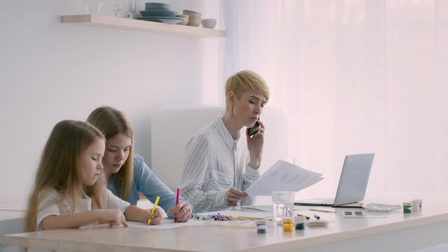 Mother Of Two Daughters Working Online Talking On Phone Indoor