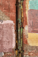 Rusty pipes against a background of multicolored graffiti painted