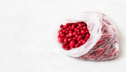 Frozen cranberries in a package closeup. Frozen berries on a white background. Homemade preparations. Copy space.
