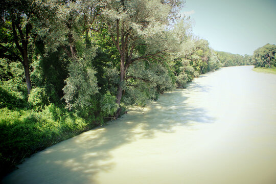 Ismaning, Bavaria, Germany - High water of the Isar river few Kilometers from Munich. The river banks are submerged and the trees seem to raise direct from the turbulent muddy waters.