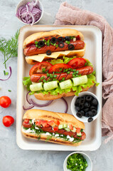Delicious freshly cooked hot dogs fully loaded with assorted toppings on a tray.