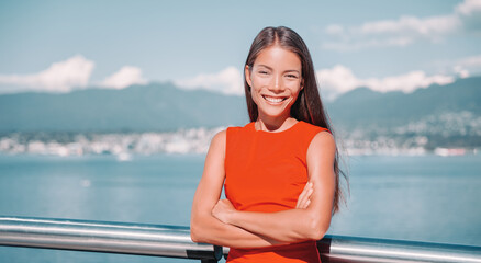 Asian business woman confident multiracial businesswoman portrait smiling with crossed arms in red top outside in Vancouver, Canada.