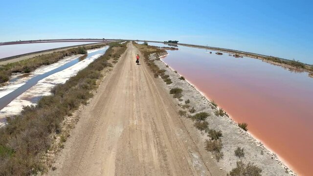 Une femme faisant du v&eacute;lo dans des marais salants