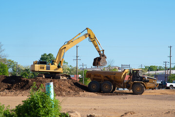 Excavator loading dumper truck tipper in sandpit gravel